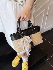 Chic woven straw handbag with black leather trim, pearl charm, and double round handles