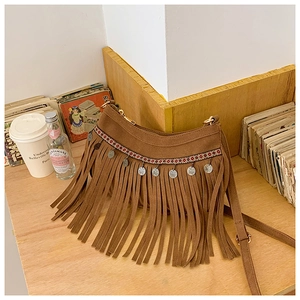 Détail d'un sac bandoulière marron style ethnique avec de longues franges et bordure