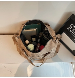 Vista dall'alto dello spazioso interno della borsa da viaggio kaki con gli oggetti
