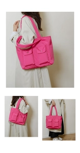 Detail view of pink nylon tote bag showing multiple pockets and wide shoulder straps