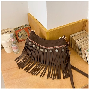 Détail du sac à bandoulière bohème avec franges en daim et ornements de pièces