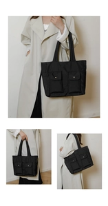 Detailed macro view of black canvas tote bag showing dual front flap pockets with silver buttons