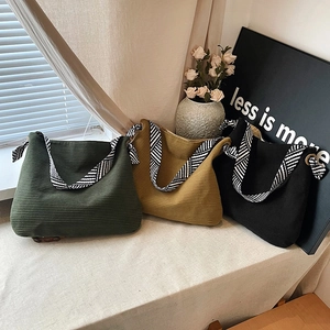 Three corduroy tote bags in olive, tan, and black with geometric patterned shoulder straps