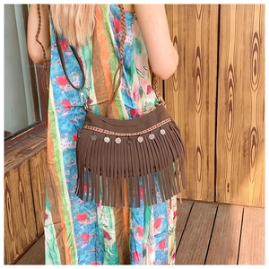 Détail du sac à franges bohème vintage avec broderie ethnique et pendentifs pièces d'argent