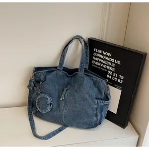 Detailed texture of blue denim tote bag with circular coin purse and vertical zipper pocket