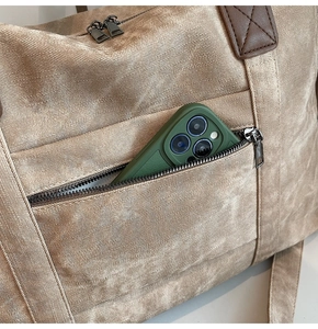 Dettaglio di una borsa da viaggio grande in tela kaki con tasca per smartphone