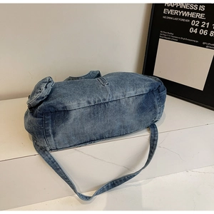 Detailed close-up showing stitching and durable denim texture of the blue tote bag