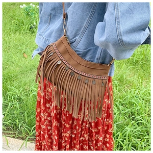 Détail d'un sac à bandoulière bohème avec franges, broderie ethnique et pièces