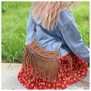 Gros plan sur sac bohème en daim marron avec franges et bandoulière ethnique