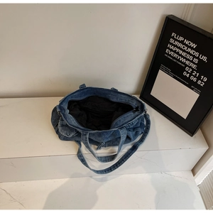 Top-down view of denim tote bag with internal zipper pocket and spacious black lining