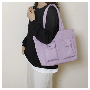 Detail view of large lavender canvas tote bag with functional front button pockets