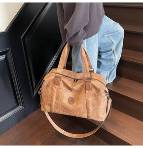 Dettaglio ravvicinato di una borsa da viaggio in pelle marrone vintage sulle scale