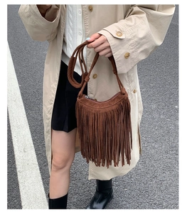 Detail view of brown suede fringe crossbody bag with bohemian style and silver zipper