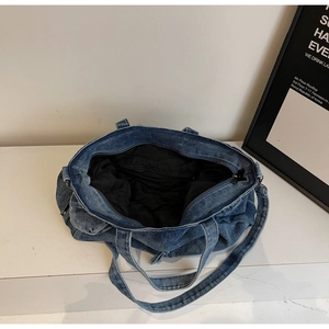 Detail view of large denim tote bag interior showing durable lining and secure zipper pocket