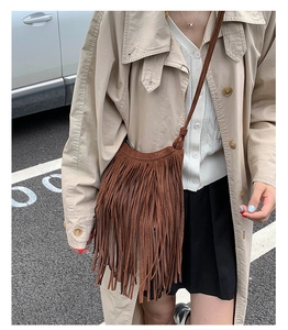 Close-up of brown suede fringe crossbody bag with vintage bohemian tassels detail