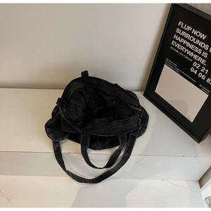 Top view of black denim tote bag interior showing inner pockets and black lining detail