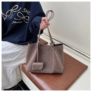 Detail of taupe frosted tote bag with slender handles and a decorative mini flap pouch