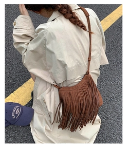 Outdoor shot of a brown fringe crossbody bag showing suede texture and boho tassels