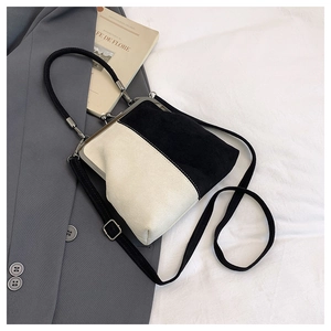 Retro black and white frame bag with metal clasp and woven handle in lifestyle setting