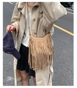Close-up of brown suede tassel bag with fringe detail in Bohemian style on a street