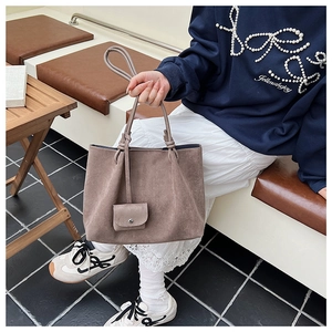 Close-up of brown matte suede tote bag with small matching pouch and delicate handles