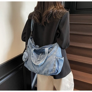 Detailed macro view of a denim tote bag with side pockets and a small round coin purse