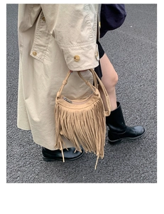 Detailed view of bohemian light brown suede tassel bag with fringe and zipper handle detail
