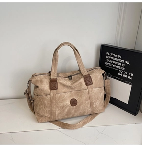 Dettaglio della borsa da viaggio kaki vintage con toppa in pelle e tessuto in tela
