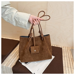 Detailed view of brown matte suede tote bag with knotted handle and matching mini pouch