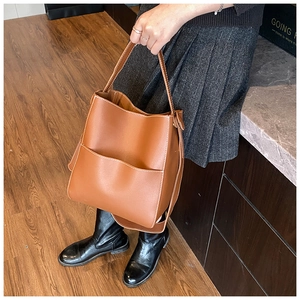 Détail du sac seau marron avec coutures contrastées blanches et grande poche avant