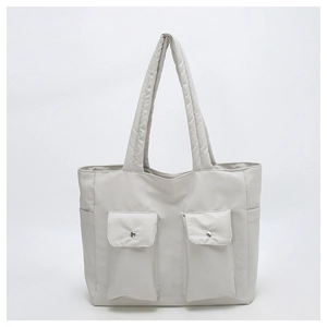 Detail of light gray canvas tote with symmetrical front flap pockets and silver buckles