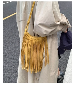 Detail of bohemian ginger yellow fringe crossbody bag showing suede texture and tassel design