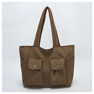 Detailed view of the dark brown canvas tote bag featuring dual front cargo flap pockets