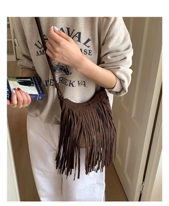 Detailed macro view of dark brown suede fringe handbag with bohemian vintage styling