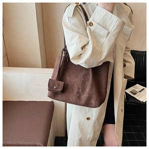 Detail of dark brown faux suede tote bag with small functional snap pocket accessory