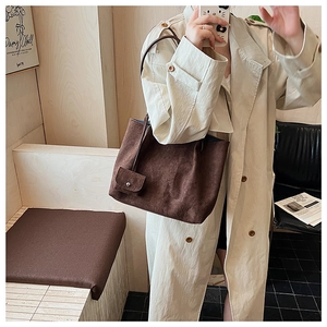 Detail of caramel suede tote bag with matching pouch and dark brown straps