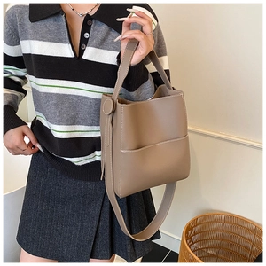 Vue détaillée d'un sac seau marron avec coutures blanches et bandoulière