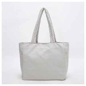 Front view of a light gray quilted tote bag with soft padded fabric and side pockets