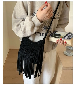 Detailed view of bohemian black fringe crossbody bag in faux suede with long tassels