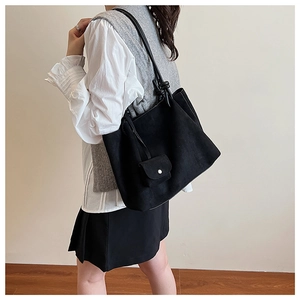 Detail of a large matte black hobo tote bag shown with an inner pouch on model