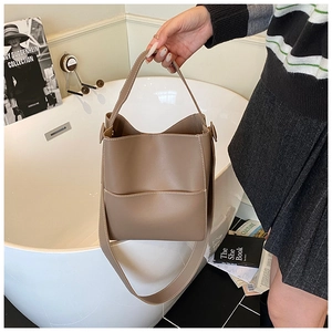Détail du sac seau kaki montrant les surpiqûres blanches et la texture cuir mat