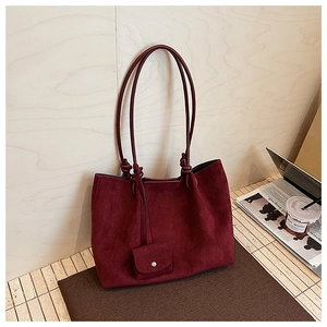 Detail of burgundy matte tote bag with matching hanging coin pouch on wooden background
