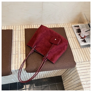 Macro view of burgundy matte tote bag with decorative knot and small matching pouch