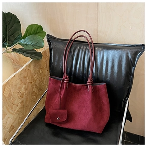 Detailed close-up of dark burgundy matte suede tote bag with knotted strap and mini pouch