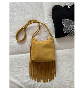 Detail of mustard yellow suede fringe crossbody bag with high quality matte texture