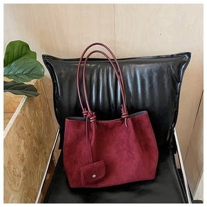 Detail of burgundy matte tote bag with knotted handle and matching mini coin purse