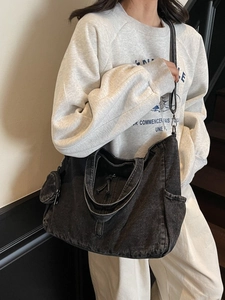 Large black denim tote bag with adjustable strap and mini coin purse in a casual style