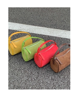 Detail of four colorful mini Boston bags in matte suede leather on asphalt background