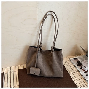 Close-up of vintage brown matte tote bag featuring a knotted strap and detachable small pouch