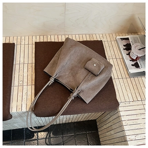 Detail view of large brown suede tote bag with a small matching pouch for commuting